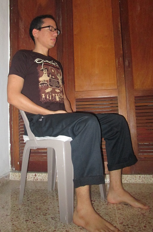 Seated meditation posture on a straight-backed chair, feet flat and knees at ninety degrees