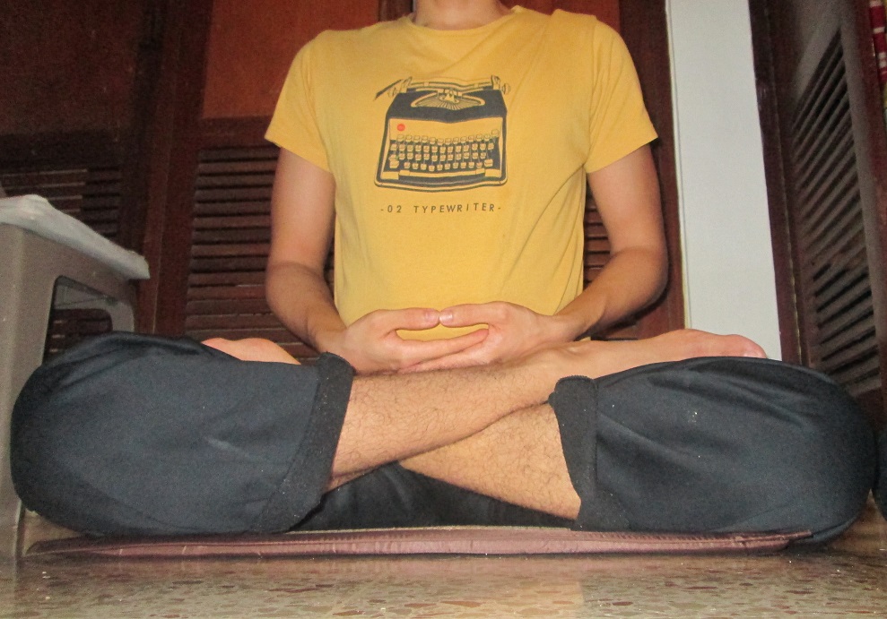 Full lotus posture with both feet drawn up onto the opposite thighs, soles facing back