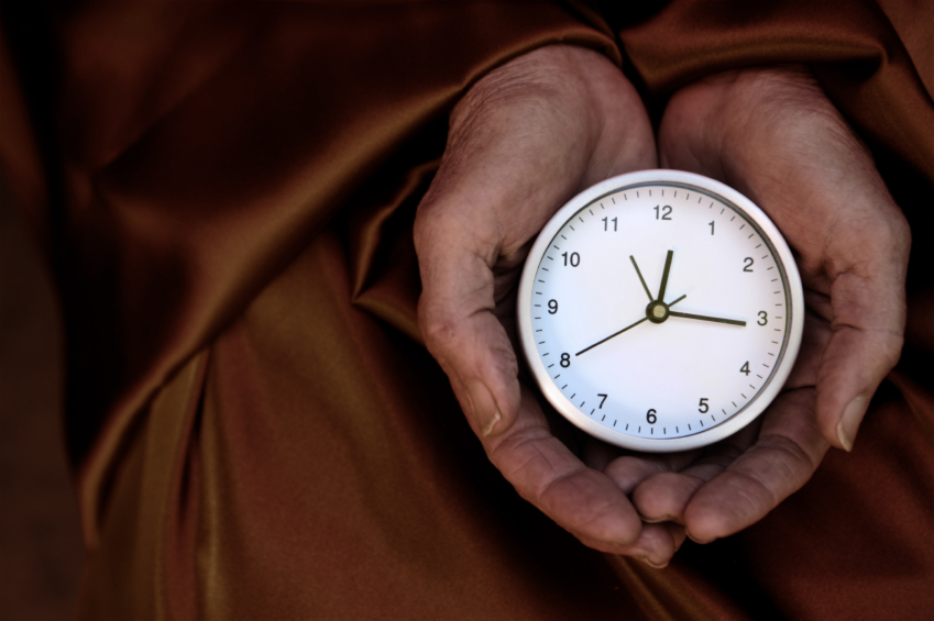 A clock beside a meditation cushion, marking out the length of a sit